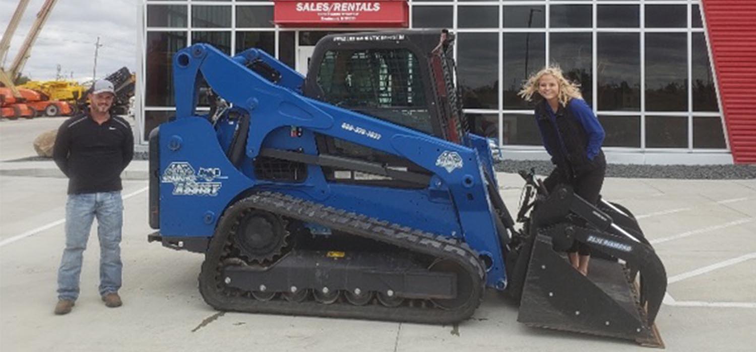 Tim Kramer of Mid Country Machinery poses with the Blue Diamond Assist Bobcat compact track loader.