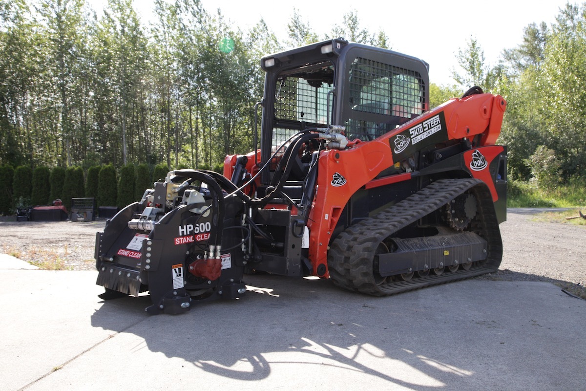 Compact track loader fitted with a concrete shaver for concrete stripping.