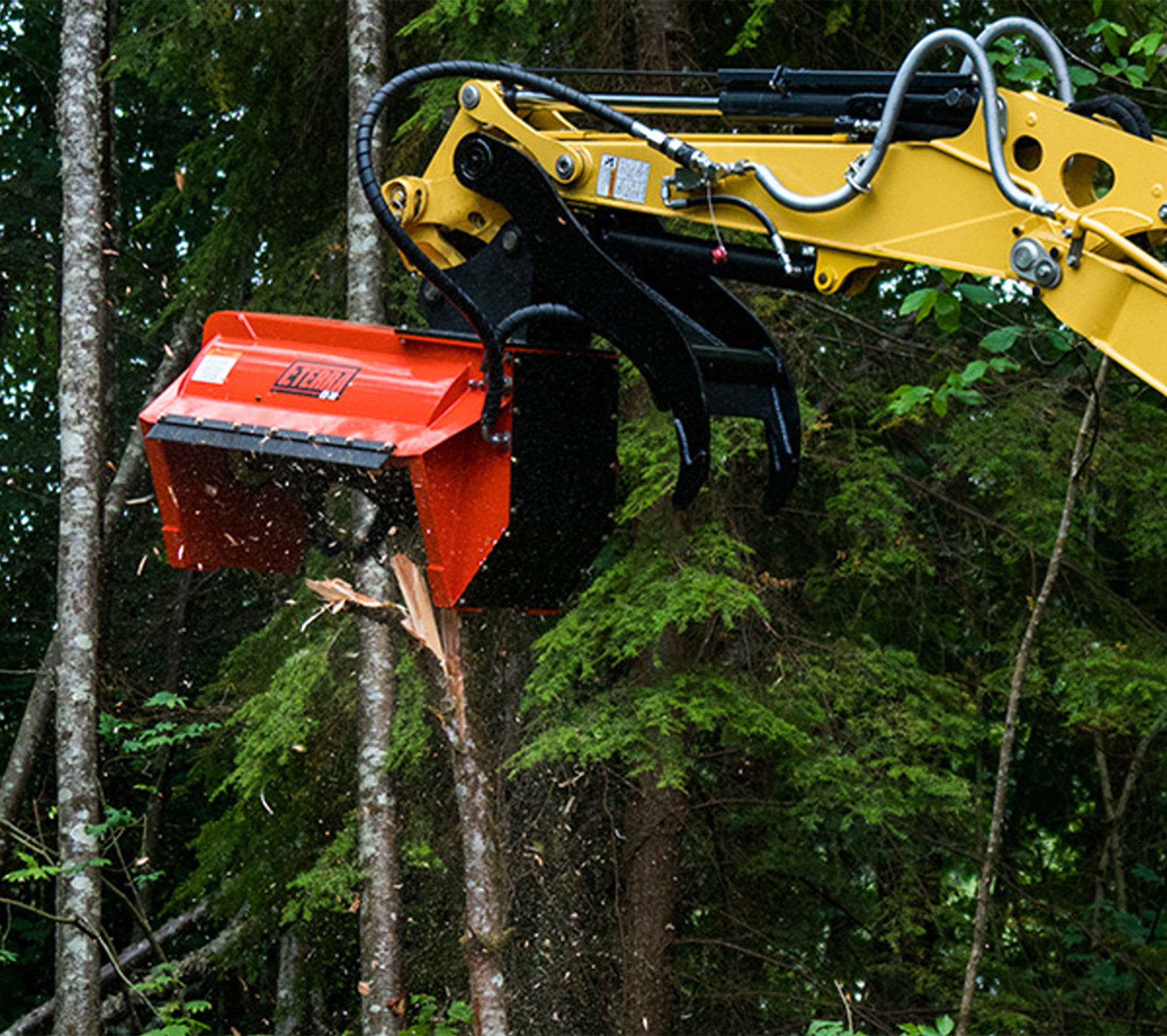 excavator arm reaching into the frame with an eterra ex-30 excavator flail mower attachment on the end of it