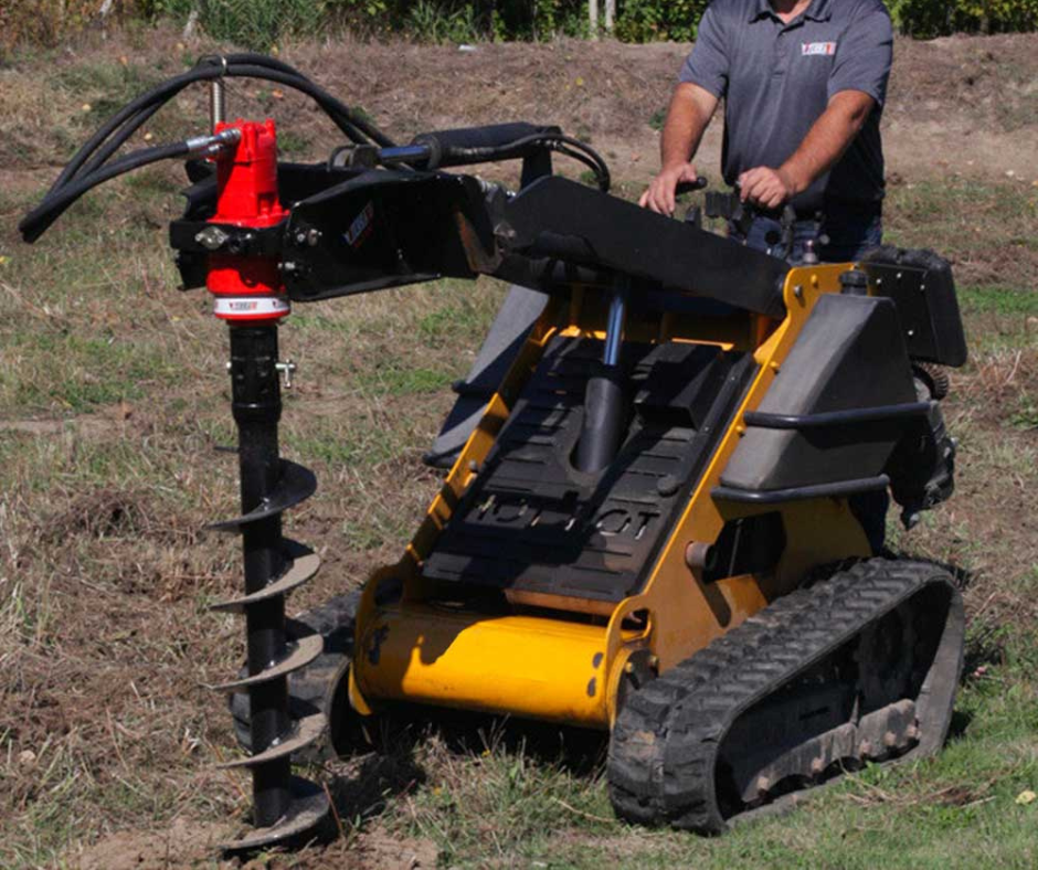 right angled view of a mini skid steer on grass with an eterra mini skid steer auger drive attachment on the front drilling into the ground