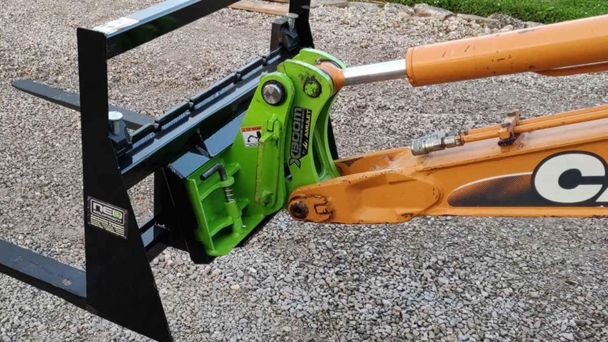 back angle view of an xboom excavator skid steer mounting system on the end of a boom